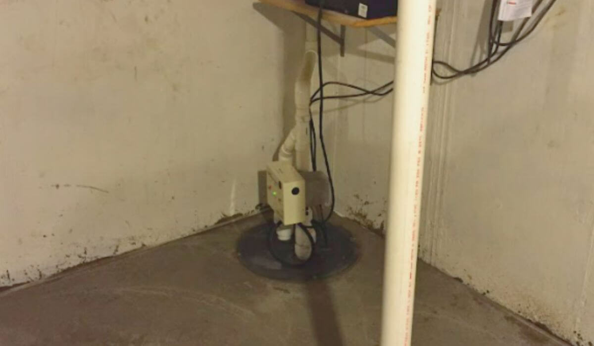 Sump pump installed in basement corner as part of effective basement waterproofing to prevent water damage.