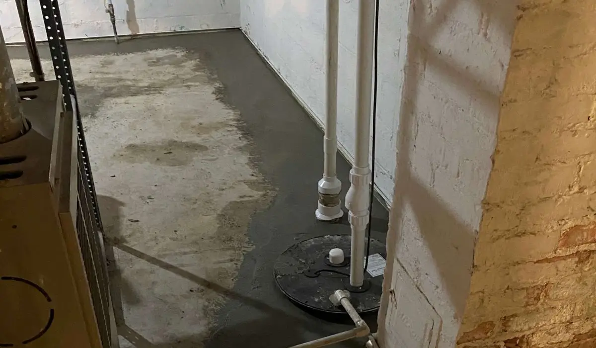 New basement waterproofing system with sump pump and sealed drain pipes protecting concrete foundation from water damage.