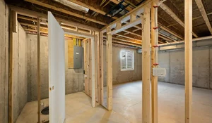 Bright unfinished basement with concrete walls showing waterproofing preparation to improve indoor air quality effectively .