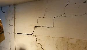 Cracked basement foundation wall showing structural damage and water intrusion, a problem solved with Titan Anchors by Premium Waterproofing.