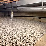 Crawl space waterproofing in Wheaton, IL with fresh gravel drainage layer and foundation sealing by Premium Waterproofing